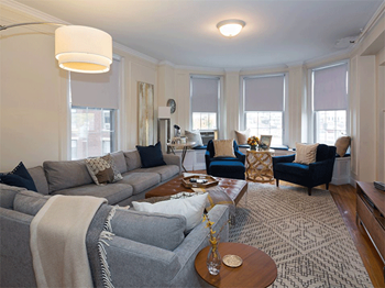 a living room with couches and chairs and a rug